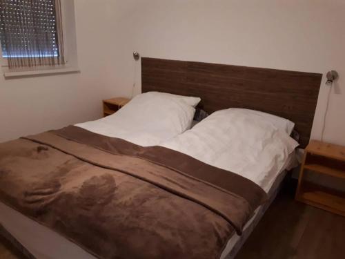 克塞洛Napkő的卧室内的一张床位,配有木制床头板