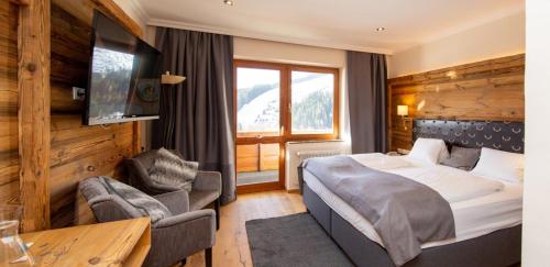 拉姆绍达赫斯坦Landhaus Ramsau的酒店的客房 - 带一张床、椅子和窗户