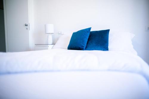 米兰米兰最佳住宿加早餐旅馆的一张带两个蓝色枕头的白色床