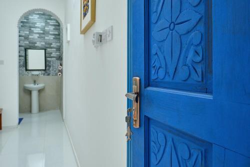 阿尔哈德Salem Fish Guest House的一个带水槽的浴室内的一扇蓝色门