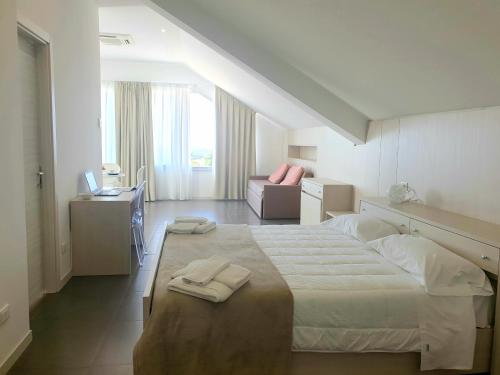 基亚拉蒙泰-古尔菲Hotel Grel的一间卧室配有一张大床和两条毛巾