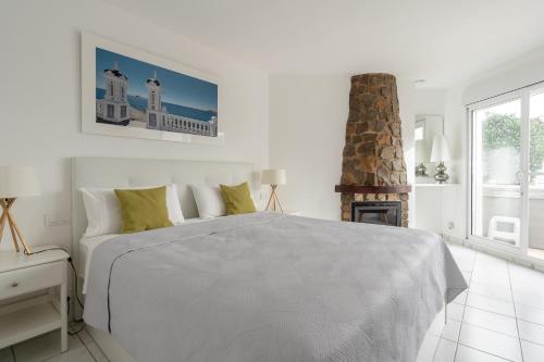 卡尔佩Maryvilla Inspiración y Vacaciones - Bungalows的白色卧室设有一张大床和一个壁炉