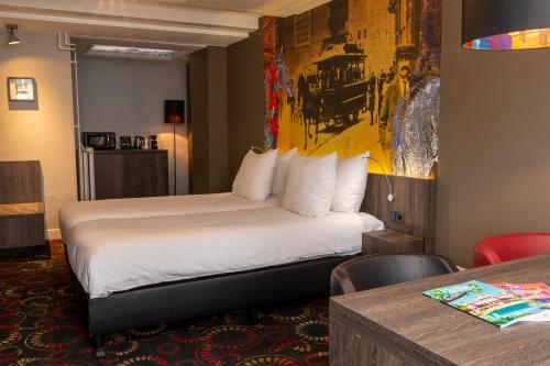 阿姆斯特丹Eden Studios and Apartments的酒店客房配有一张床铺和一张桌子。