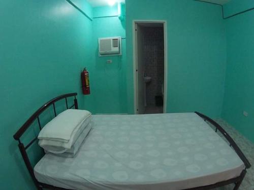 宿务Cebu Leisure Lodge的蓝色墙壁间的一张床位