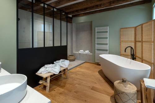 布鲁日马丁斯拉列斯酒店的一间带大浴缸和两个盥洗盆的浴室