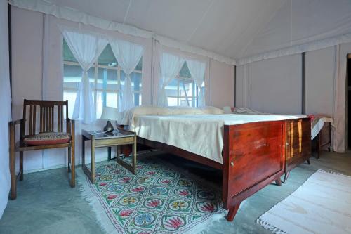 KuttaDevi Villa - Plantation Retreat and Forest Getaway的卧室配有1张床、1张桌子和1把椅子