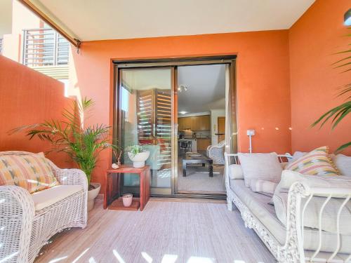 拉特吉塔MEDANO4YOU La Terraza De Isa的客厅拥有橙色墙壁和白色家具