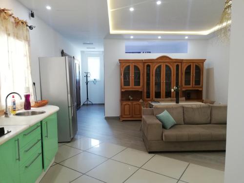 莫纳斯提尔Residence Debbabi的厨房以及带沙发和冰箱的客厅。