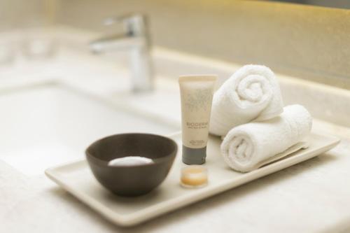 纳塔列斯港科斯淘斯特雷莱丝酒店的浴室柜台配有带毛巾的盘子和1瓶肥皂