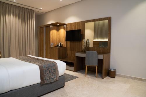 吉达Sarwat Park Hotel Jeddah的配有一张床和一张书桌的酒店客房