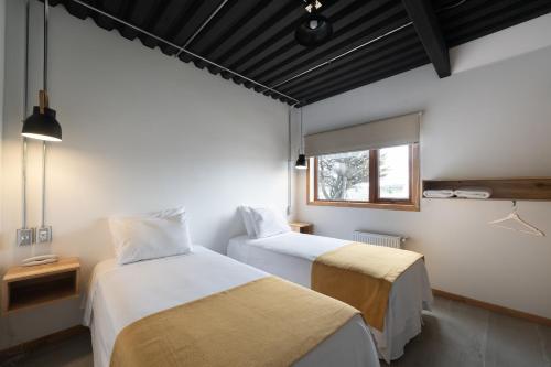纳塔列斯港Hotel Big Sur的客房设有两张床和窗户。