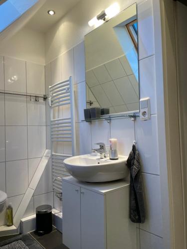埃姆登Ferienwohnung Lüttje Hörn的白色的浴室设有水槽和镜子
