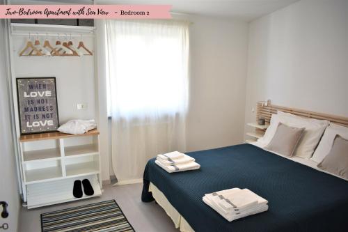 维亚雷焦FrontBeach Attic Apartment - with access to beach club的一间卧室配有一张带蓝色床单的床和一扇窗户。