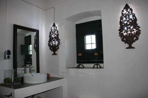 埃武拉Casa das Moles的浴室设有两面镜子、一个水槽和一面镜子
