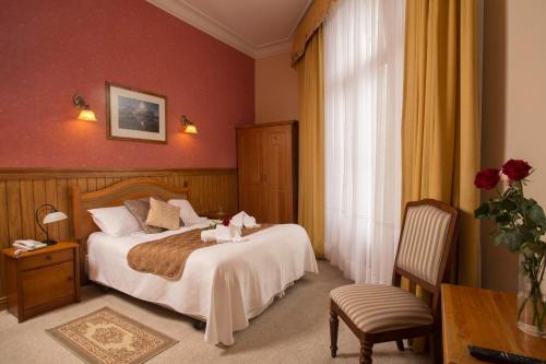 蓬塔阿雷纳斯广场酒店的卧室配有1张床、1张桌子和1把椅子