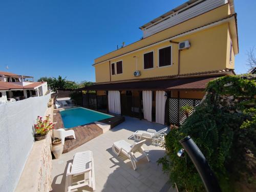 阿沃拉villa xenia的一个带游泳池和房子的庭院