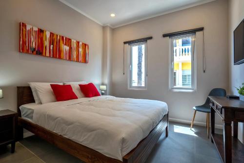 奥拉涅斯塔德Apt 27 CityLife Aruba的一间卧室配有一张带红色枕头的床和一张书桌