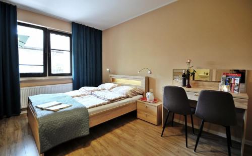 科沃布热格BALTIC VIBES - pokoje gościnne的一间卧室配有一张床和一张带椅子的桌子