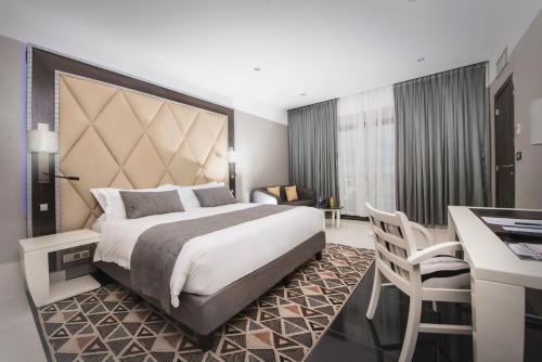 杜阿拉Krystal Palace Douala的酒店客房设有一张大床和一张书桌。
