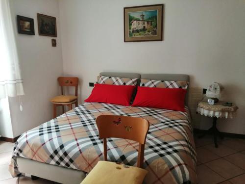 圣佩莱格里诺温泉Casa Marina的小卧室配有红色枕头的床