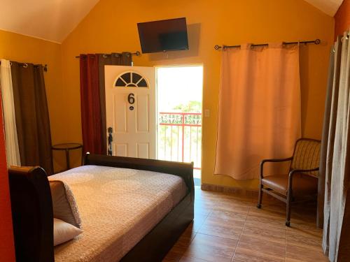 瓜达鲁佩镇Posada Del Valle的一间卧室配有一张床,一扇门设有窗户