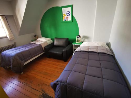 圣卡洛斯-德巴里洛切Cinerama Hostel的一间卧室设有两张床和绿色的墙壁