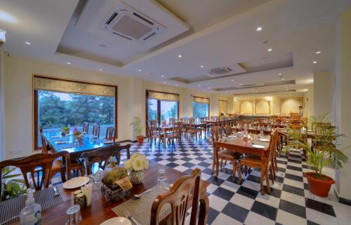 萨瓦伊马多普尔WelcomHeritage Mount Valley Resort Ranthambore的一间带桌椅和 ⁇ 制地板的餐厅