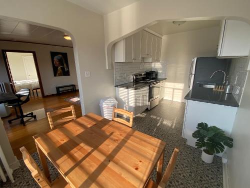 西雅图Furnished Apartments - Climate Pledge Arena Next Door的厨房以及带木桌的用餐室。