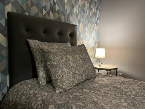 AizkraukleAizkraukle Penthouse apartment的一间卧室配有一张带枕头和桌子的床