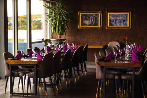 雷克雅未克Hotel Kriunes的用餐室配有桌椅和紫色餐巾