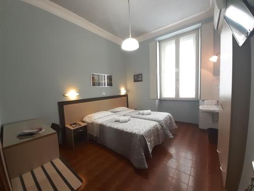 都灵Albergo in Centro的一间卧室设有一张大床和一个窗户。