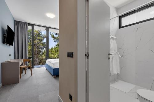 马卡尔斯卡Kuk Oaza Luxury Villas的带淋浴的浴室和卧室