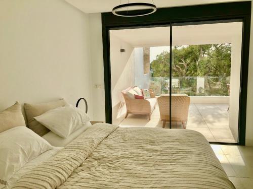 卡博皮诺Modern Apartment in front of Cabopino Golf的一间卧室设有一张床和一个滑动玻璃门
