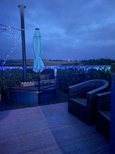 GamrieCroft B&B Accommodation With Hot Tub的一个带遮阳伞的庭院和一个带蓝色灯光的花园