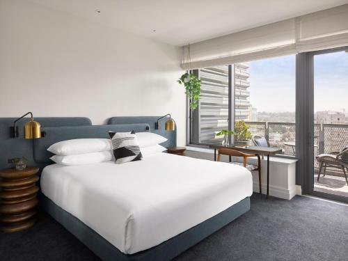 圣地亚哥Kimpton Alma San Diego, an IHG Hotel的一间带一张白色大床的卧室和一个阳台