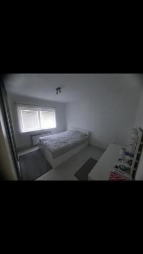 萨拉热窝Sarajevo的一间小卧室,配有床和窗户