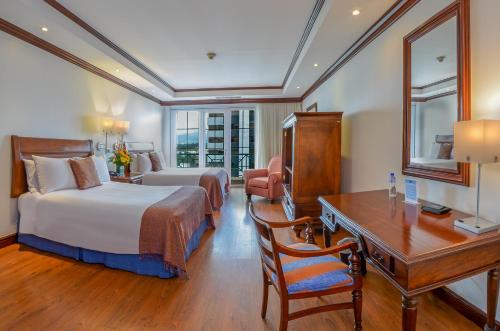 危地马拉瓜地马拉卡萨维兰达酒店的酒店客房配有两张床、一张书桌和一张书桌。