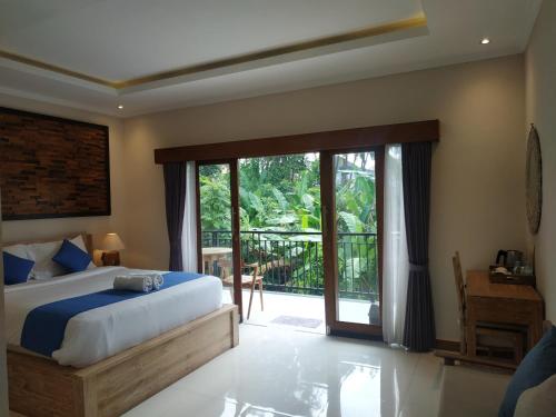 乌布Cahaya Guest House的一间卧室设有一张床和一个滑动玻璃门