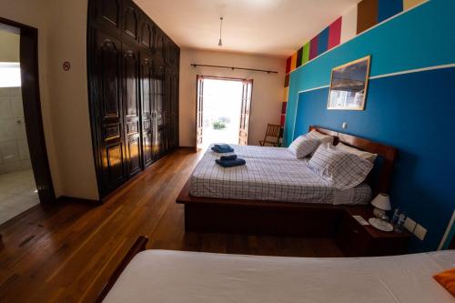 明德卢Guest House Montanha的一间卧室设有两张床和蓝色的墙壁