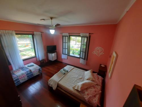 塞拉内格拉Pousada Por do Sol的一间卧室拥有橙色的墙壁,设有一张床和两个窗户。