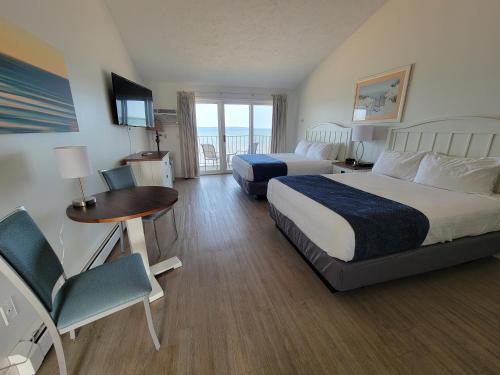 特拉弗斯城柏银特北海滨度假酒店的酒店客房带两张床和一张桌子以及椅子。