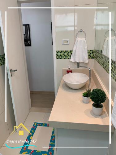 安格拉杜斯雷斯Angra Hostel 147的浴室设有白色水槽和镜子