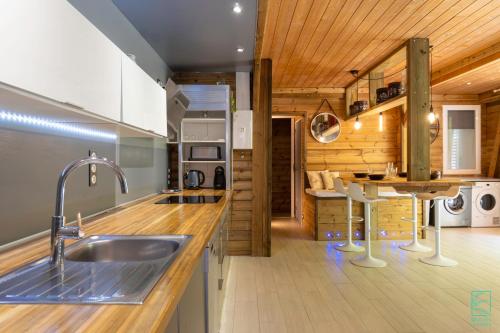 德赛Magnifique et spacieux T2 proche de la plage - La Kiss House的一个带水槽和木制天花板的厨房