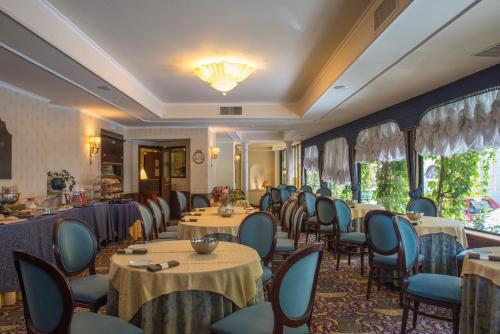 博尔塞纳Hotel Columbus sul Lago的一间带桌椅和吊灯的餐厅
