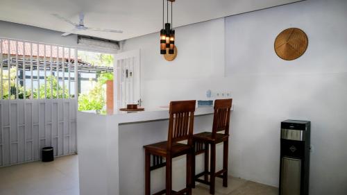 艾湄湾BALI AMED FEEL HOME VILLA的厨房配有柜台和椅子