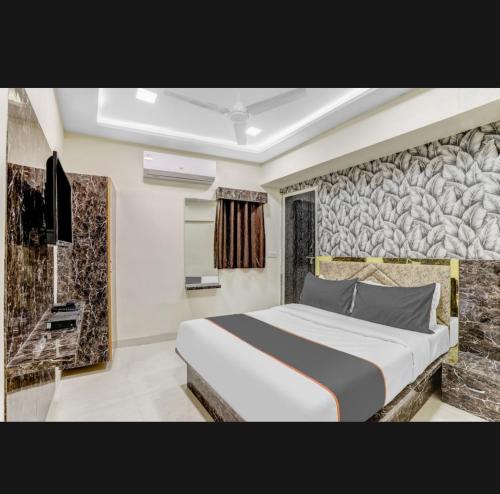 加姆布Hotel Bhavya Residency的一间卧室设有一张大床和石墙