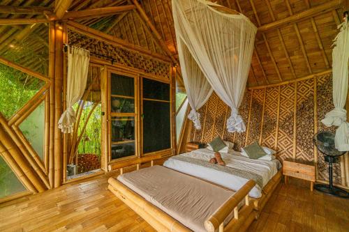卡朗阿森Bird Hills Bamboo House的一间设有床铺的卧室,位于带窗户的房间内