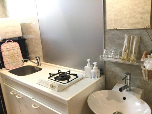 洲本市アパートメントホテル Mimoza的一间带水槽和炉灶的浴室