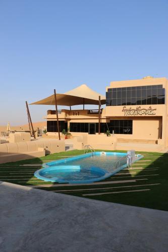 Al RakaSand House ساند هاوس的大楼前的大型游泳池