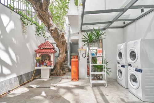 胡志明市M Village Tú Xương的洗衣房配有洗衣机和树